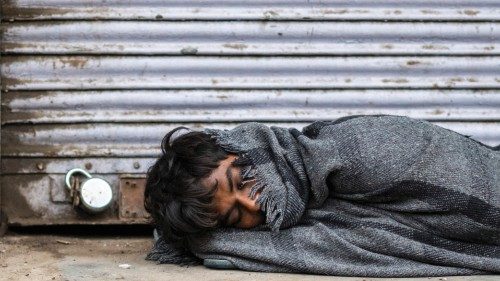 A man sleeps in front of a closed shop during a government-imposed lockdown forced to prevent the ...