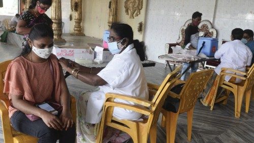 A health worker inoculates a woman with a dose of the Covishield vaccine against the Covid-19 ...