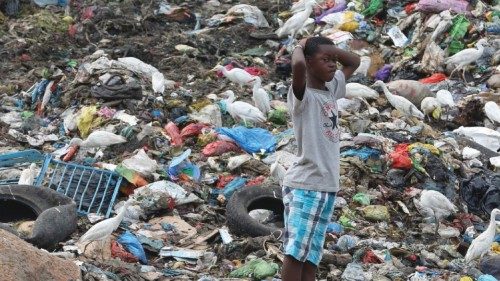 A young man stands between trash at the Mindoubé dump in Libreville on June 18, 2021. - Dozens of ...