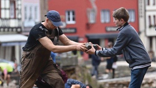 People collect debris in the pedestrian area of Bad Muenstereifel, western Germany, on July 16, ...