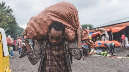 A street vendor carries a bag of onions at a market in Hawassa, Ethiopia, on July 20, 2021. (Photo ...