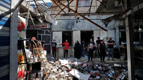 Iraqis inspect the site of the explosion a day earlier in a popular market in the Shiite-majority ...