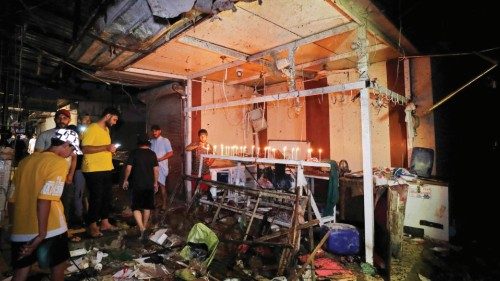 TOPSHOT - Iraqis light candles at the site of the explosion in a popular market in the mostly Shiite ... TOPSHOT - Iraqis light candles at the site of the explosion in a popular market in the mostly Shiite ...