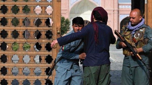 TOPSHOT - An Afghan security personnel frisks a devotee at the entrance of a mosque during the Eid ...