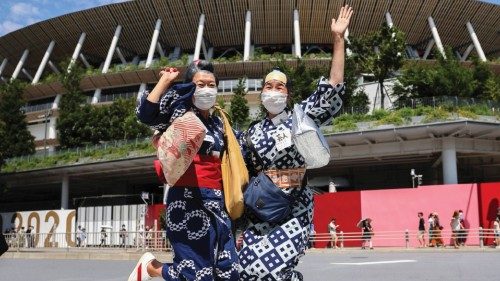 Women wearing traditional summer Yukata kimonos and wigs jump in front of the National Stadium, the ...