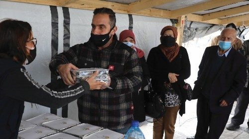 A volunteer gives out food handouts to people in need at the Lebanese Grassroots organisation in ...