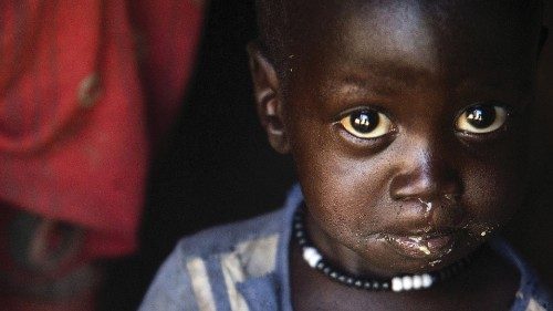 A boy eats out of a ladle at his home in Ngop in South Sudan's Unity State on March 10, 2017. - The ...