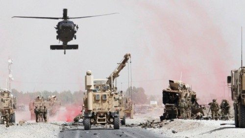 U.S. troops assess the damage to an armoured vehicle of NATO-led military coalition after a suicide ...