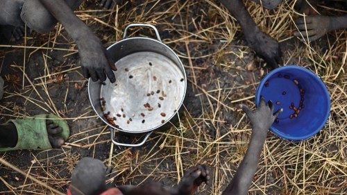 Children collect grain spilt on the field from gunny bags that ruptured upon ground impact following ...