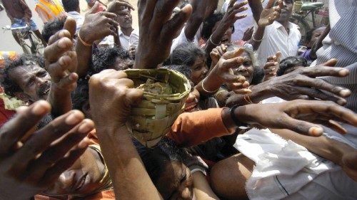 Displaced people struggle for food packets distributed at a relief camp in Nagapattinam some 350 kmS ...