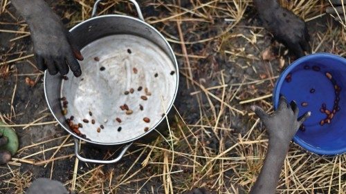 Children collect grain spilt on the field from gunny bags that ruptured upon ground impact following ...