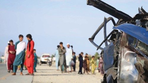 epa09356798 Afghans gather at the scene of a road side bomb blast that killed six civilians on the ...