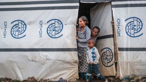 Internally displaced people stand at the door of a shelter at a camp in the town of Azezo, Ethiopia, ...