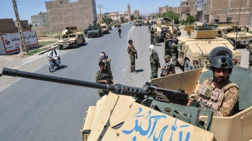 An Afghan National Army commando stands guard on top of a vehicle along the road in Enjil district ...