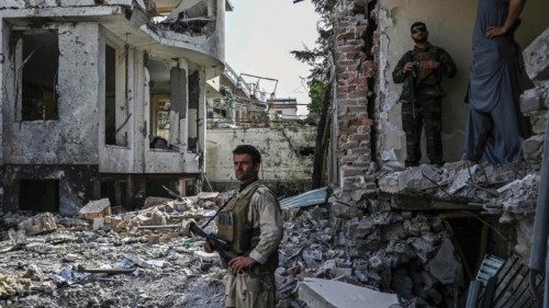 CORRECTION / An Afghan security personnel inspects the site a day after a car bomb explosion in ...