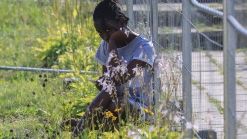 A migrant is pictured on the former school grounds turned into a refugee facility, in Vydeniai ...