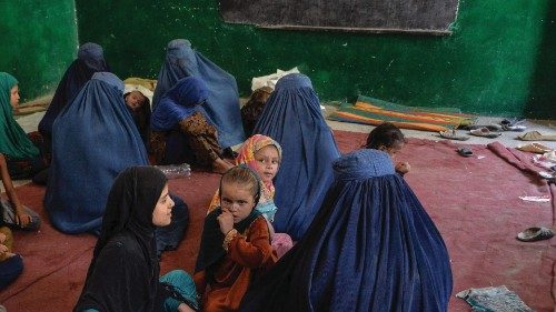 Internally displaced families sit inside a school after they left their house following fighting ...