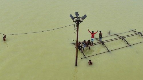 TOPSHOT - Boys along with local boatmen play atop a submerged structure at Daraganj Ghat, one of the ...