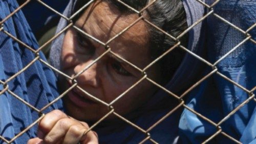 FILE PHOTO: Afghan women wait to receive free wheat donated by the Afghan government during a ...