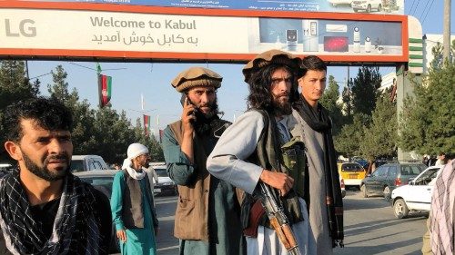A member of Taliban (C) stands outside Hamid Karzai International Airport in Kabul, Afghanistan, ...