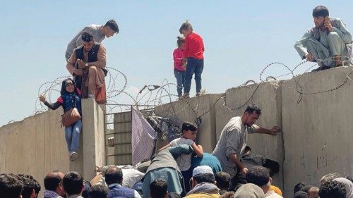 A man pulls a girl to get inside Hamid Karzai International Airport in Kabul, Afghanistan August 16, ...