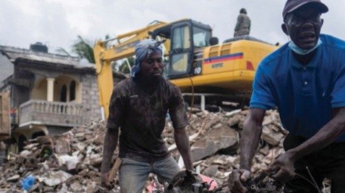 Men remove debris from a destroyed building after Saturday's 7.2 magnitude quake, in Les Cayes, ...