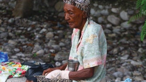 An elder person sits on the street, worried damaged structures may collapse, in the area of Les ...