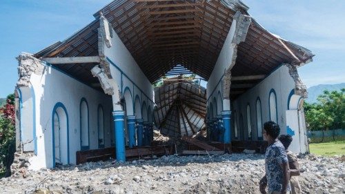 TOPSHOT - Two Haitians walk past a church destroyed during an earthquake in Les Anglais on August ...