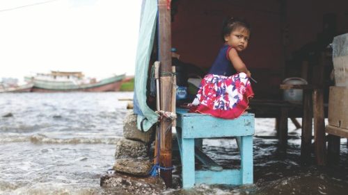 FILE PHOTO: Shaqueena Dwi Arsyilla, 2, sits on a bench at Kali Adem port, which is impacted by high ...