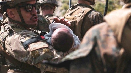 In this image courtesy of the US Central Command Public Affairs, A US Airmen comforts an infant ... In this image courtesy of the US Central Command Public Affairs, A US Airmen comforts an infant ...