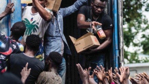 Men hand out supplies to a crowd of earthquake victims during the distribution of food and water at ... Men hand out supplies to a crowd of earthquake victims during the distribution of food and water at ...