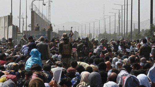 TOPSHOT - Afghans gather on a roadside near the military part of the airport in Kabul on August 20, ...