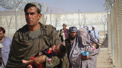 Afghans walk along fences as they arrive in Pakistan through the Pakistan-Afghanistan border ...