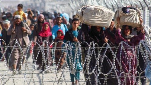 Afghans walk along fences as they arrive in Pakistan through the Pakistan-Afghanistan border ...