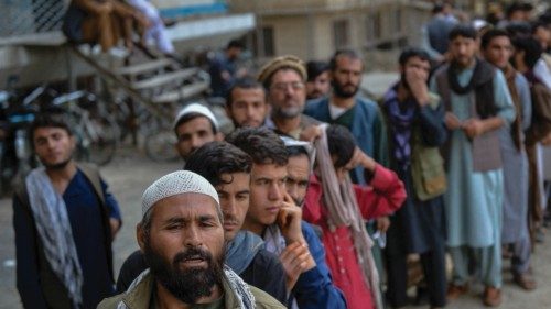 Afghans queue up as they wait for the banks to open and operate at a commercial area in Kabul on ...