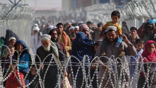 Afghans walk along fences as they arrive in Pakistan through the Pakistan-Afghanistan border ...