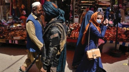 A Taliban fighter (C) walks past shoppers along Mandawi market in Kabul on September 1, 2021 a day ...