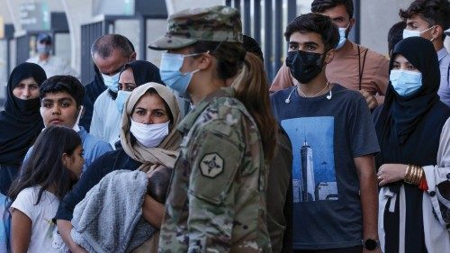 Afghan refugees wait to board buses that will take them to a processing center after arriving at ... Afghan refugees wait to board buses that will take them to a processing center after arriving at ...