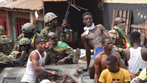 People celebrate in the streets with members of Guinea's armed forces after the arrest of Guinea's ...