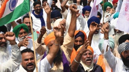 Farmers shout slogans as they make their way to Delhi to join farmers who are continuing their ...