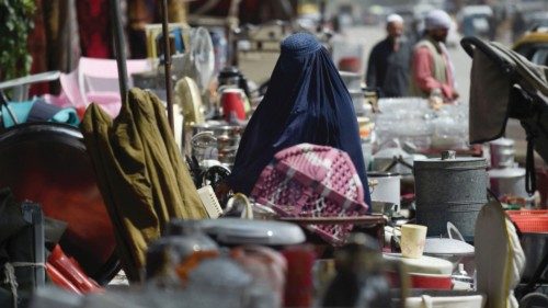 This photo taken on September 12, 2021 shows a woman looking at secondhand household items for sale ...