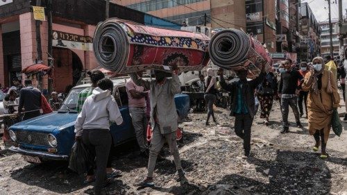 Workers carry blankets on their heads in the historical Merkato district during the preparations for ...