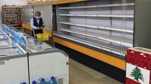 A shopper walks past an empty shelf at a supermarket in Hammana, Lebanon, August 22, 2021. Picture ...