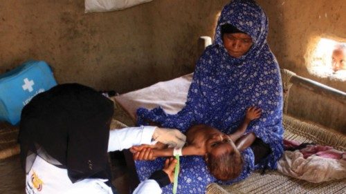 Volunteer health worker Ashwaq Muharram measures the arm of a girl to assess her nutritional status ...