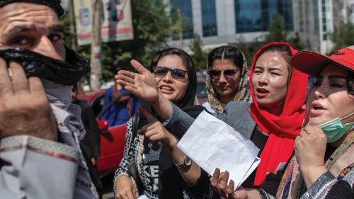 Afghan women converse with a man while they hold placards during a demonstration demanding better ...