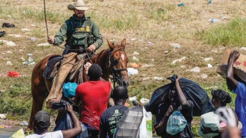A United States Border Patrol agent on horseback spins a rope as he tries to stop Haitian migrants ...