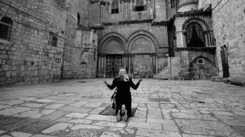 A picture taken on March 2020 shows a Christian worshipper kneeling as she prays in front of the ...