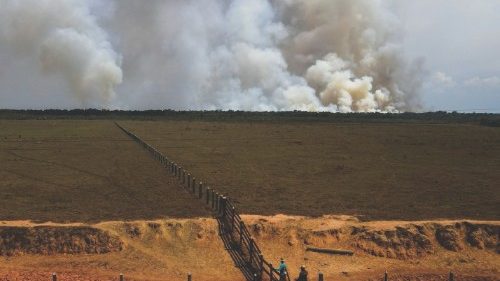 Farmers are seen as smoke from burning vegetation rises in Brazilian Amazon rainforest near the ...