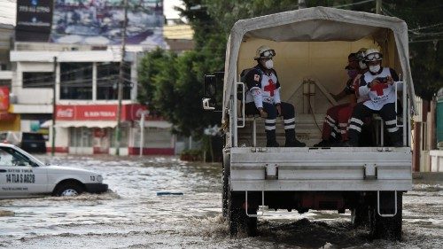 TOPSHOT - Members of the Red Cross patrol the flooded streets after heavy rains fell over Tula de ...