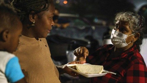 TOPSHOT - Mari Jaona gives Haitian Naomi and her son David, 3, a plate of food in Parque Ecologico ...